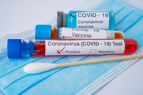 Позитивний зразок інфекції крові в пробірці для коронавірусу ковідо-19 з вакциною, що лікується маскою для обличчя
.   - Фото, зображення