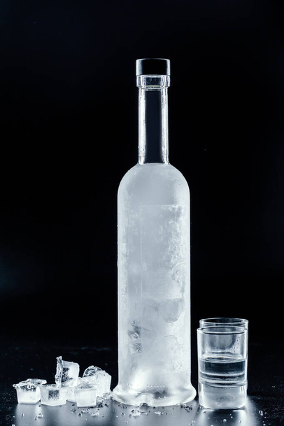 Bottle of cold vodka on dark background - Фото, зображення