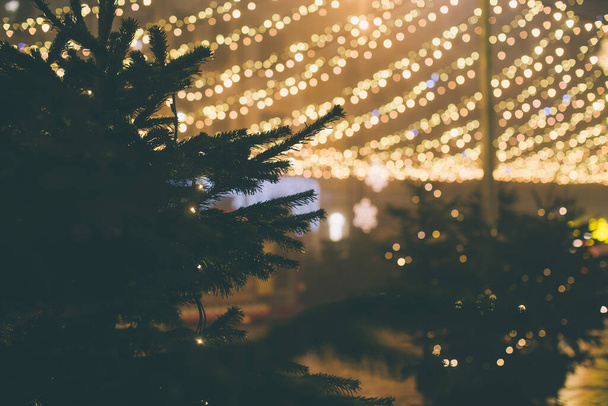 Gold Christmas background of de-focused lights with decorated tree - Foto, imagen