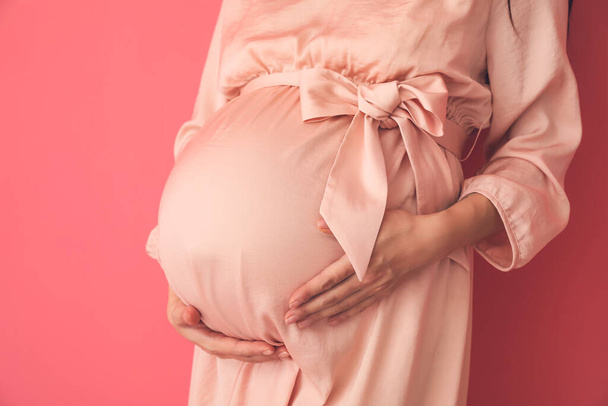 Renkli arka planda hamile genç bir kadın. - Fotoğraf, Görsel