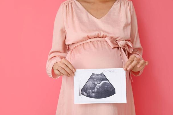 Jovem grávida com imagem de ultrassonografia sobre fundo de cor - Foto, Imagem