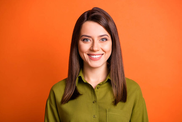 Photo of lovely young girl look camera toothy beaming smile wear green shirt isolated orange color background - Valokuva, kuva