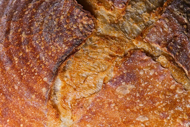 Detail of top of home made craft bread with nice crispy textured brown crust - Foto, afbeelding