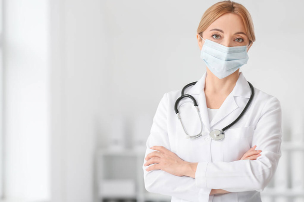 Portrait of female doctor wearing medical mask in clinic - Foto, Imagen