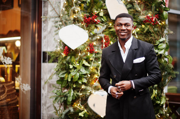 Portrait of young and handsome african american businessman in suit near new year tree decorations. - Photo, Image