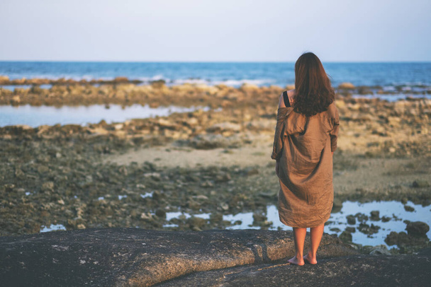 Visão traseira de uma bela mulher asiática sozinha na praia à beira-mar - Foto, Imagem