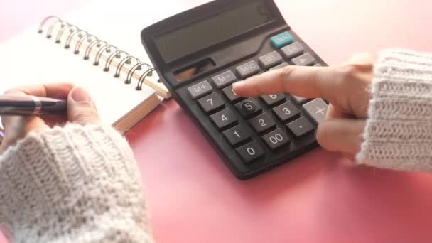 Női kéz segítségével számológép az irodai asztalon  - Felvétel, videó
