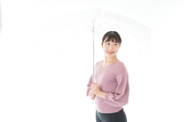 傘を差した若いアジア人女性 - 写真・画像