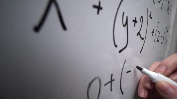 Writing mathematics equation on whiteboard, math formula, education concept - Кадры, видео