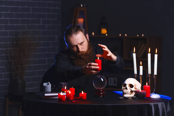 Male fortune teller with candle at table - Photo, Image