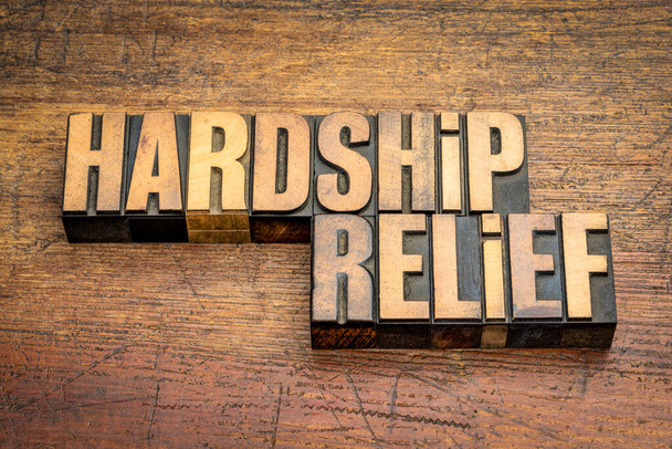 hardship relief word abstract in vintage letterpress wood type against rustic wooden background, help, support and assistance - Foto, Bild