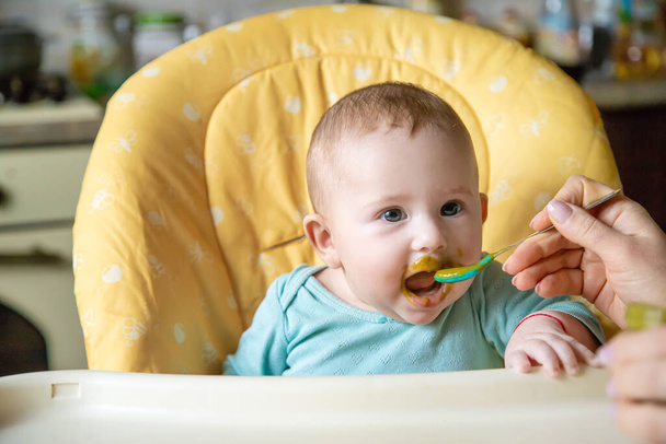 小さい赤ん坊はブロッコリーの野菜のピューレを食べている。選択的フォーカス。人々. - 写真・画像
