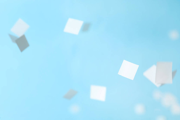 White confetti falling down on light blue background - Fotografie, Obrázek