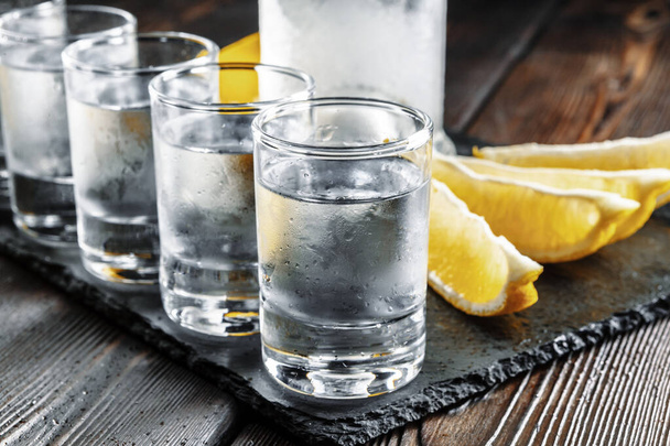 Vodka in shot glasses on rustic wood background - Foto, Imagen