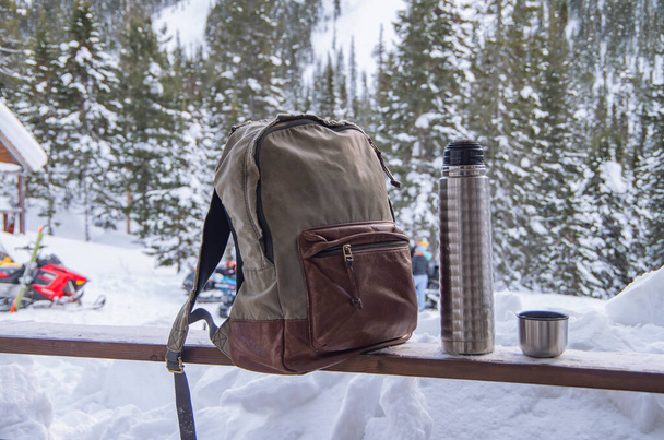 Backpack for tourist accessories, on a wooden board on a background of snow. - Photo, Image