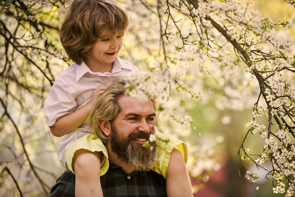 Best dad ever. Child having fun with dad. Happy family. Little boy and father in nature background. Springtime. Hipster piggybacking baby. Bearded brutal man good father. Fathers day. Dad and son - Fotoğraf, Görsel