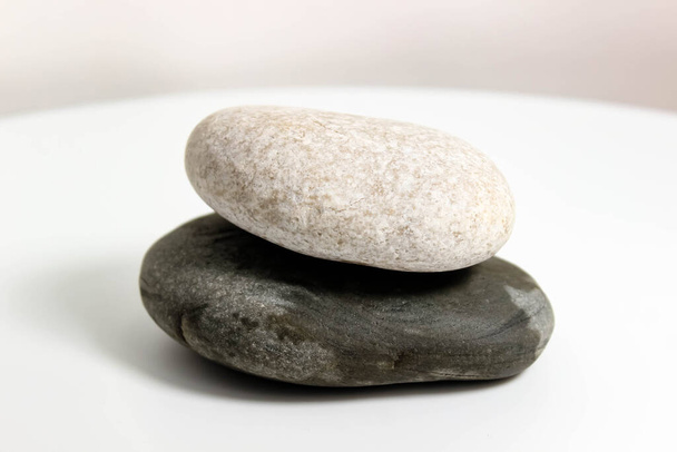 Два гладких морських камені крупним планом на білому тлі. Вибірковий фокус
. - Фото, зображення