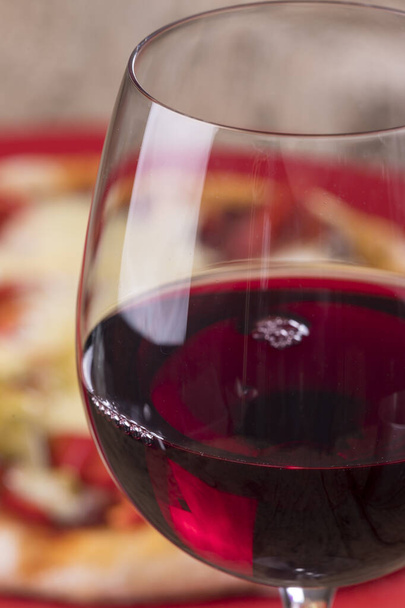 closeup of red wine with a pizza - Фото, изображение