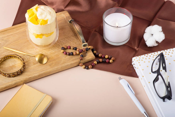 Κερί, ημερολόγιο στο τραπέζι. Χώρος εργασίας με ημερολόγιο, στυλό, vintage λευκό δίσκο, sakura, τριαντάφυλλα, κρουασάν και καφέ σε λευκό φόντο. Πάνω άποψη, επίπεδη lay - Φωτογραφία, εικόνα