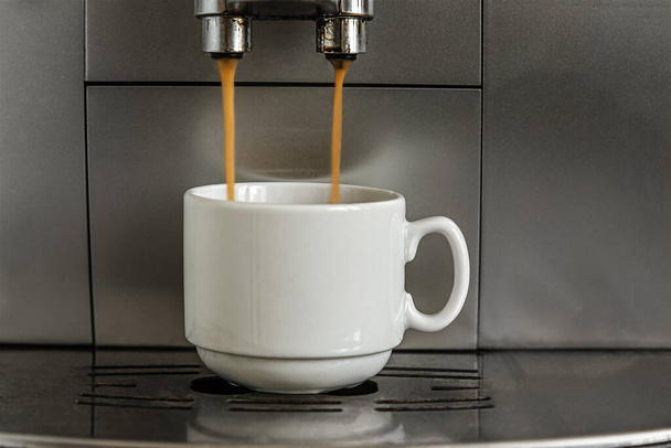koffie zetten in een koffiezetapparaat in wit porseleinen kopje - Foto, afbeelding