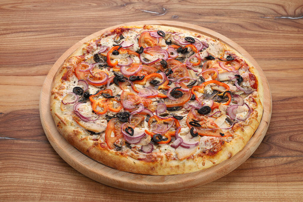 large uncut pizza on a wooden plate - Photo, Image