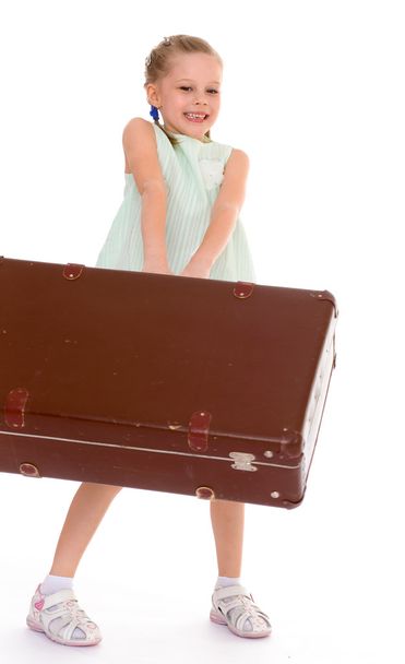  little girl with a big and very old suitcase. - 写真・画像