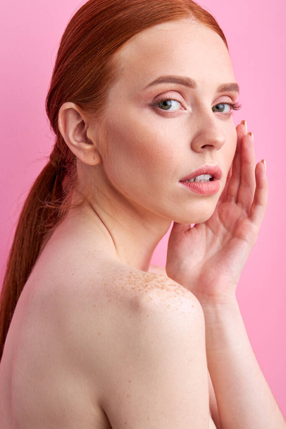 shirtless redhead woman touching face isolated on pink - Foto, imagen