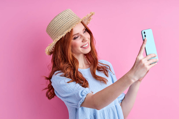 portrait of pretty cute redhead woman taking photo on mobile phone - Photo, image