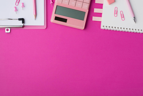 Workspace concept. Top above overhead close up flat lay view photo picture mock up of office supplies and calculator isolated bright color pink backdrop with space for design text - Photo, Image