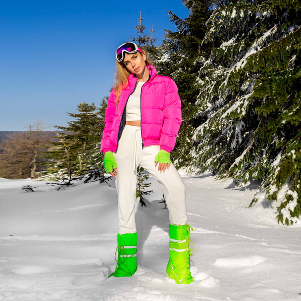 Retrato de invierno de mujer joven. Modelo de moda de invierno con traje de esquí y gafas. Mujer joven atractiva en invierno al aire libre. Montañas, nieve blanca en el mágico día de invierno. - Foto, Imagen