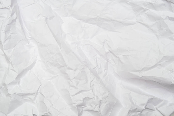A background of sheet of white crumpled paper with wrinkles, backdrop for design and web - Photo, Image