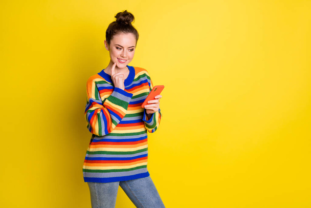 Photo of thoughtful brunette top-knot haired girl hold phone wonder message wear jeans isolated on vivid color background - Valokuva, kuva