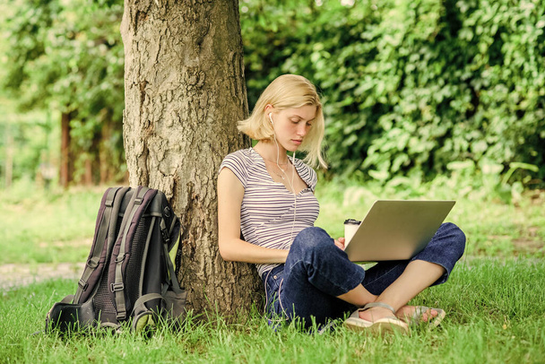 Work in summer park. Girl work with laptop in park. Reasons why you should take your work outside. Lunch time relax or coffee break. Nature is essential to wellbeing and ability to be productive - Фото, изображение