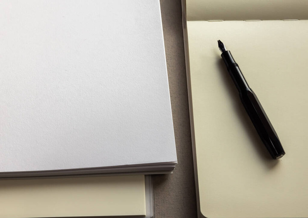 чистые листы, блокнот, тетрадь и ручка на сером фоне  - Фото, изображение