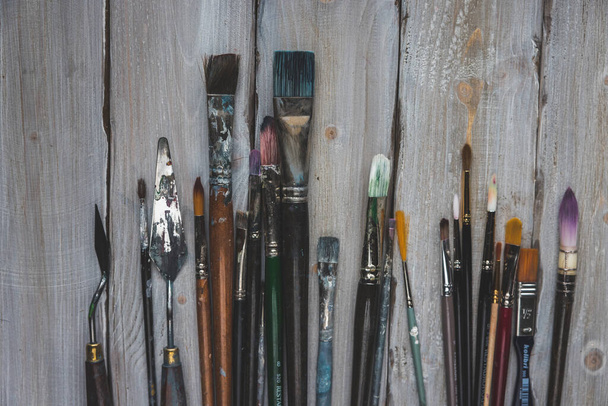 dirty brushes and spatula  on white wood background - Photo, Image