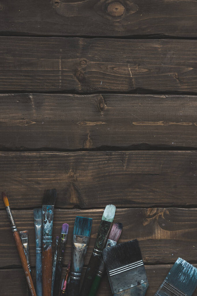 Kahverengi ahşap arka planda kirli fırçalar - Fotoğraf, Görsel