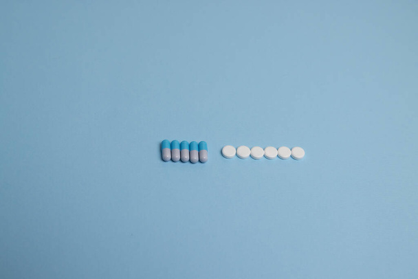 píldoras azules y blancas sobre fondo azul - Foto, Imagen