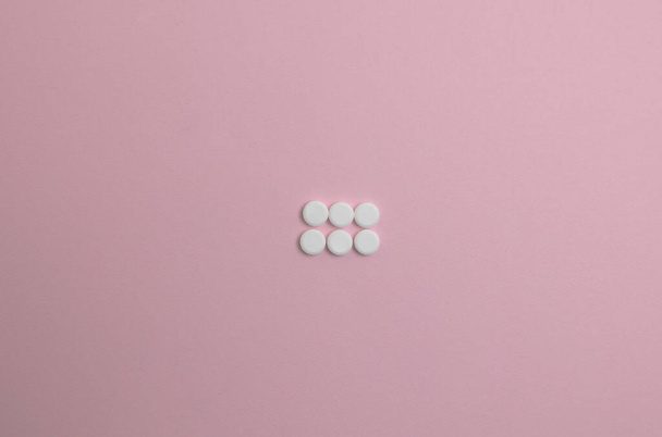 white pills on pink background - Foto, afbeelding