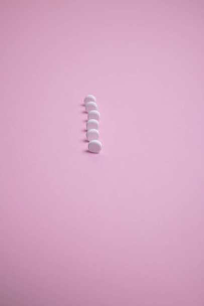 white pills on pink background - Фото, зображення