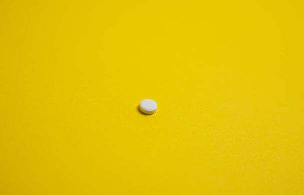 λευκό χάπι σε κίτρινο φόντο - Φωτογραφία, εικόνα