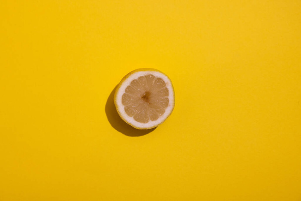 половина лимона, на жовтому фоні, тверда тінь
  - Фото, зображення