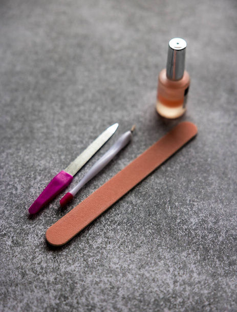 ferramentas de manicure rosa e esmalte de unhas em fundo cinza  - Foto, Imagem