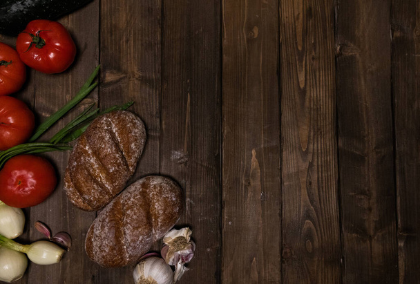 vegetables and bread on a wooden background  - Fotó, kép