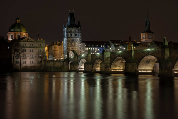 widok Mostu Karola na rzece Wełtawie i światło z oświetlenia ulicznego w nocy w centrum Pragi - Zdjęcie, obraz