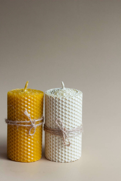 Белые и желтые свечи из воска с металлическим горшком на белой и коричневой бумаге - Фото, изображение