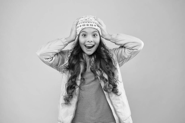 Full of happiness. warm clothes for cold season. knitted accessory. small girl winter hat. kid fashion. trendy girl look like hipster. surprised child pink background. autumn style. happy childhood - Foto, imagen