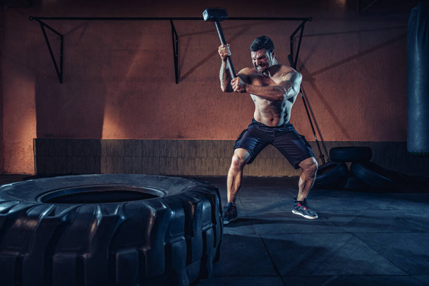 Sports training for endurance, man hits hammer. Concept workout - Fotó, kép