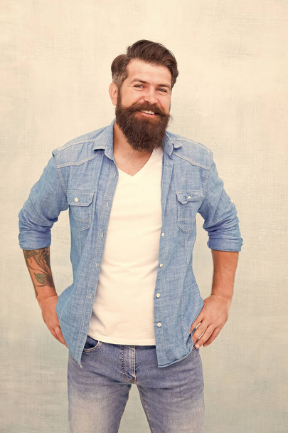 Good vibes. Charismatic barber with beard and mustache. Personality and Charisma concept. Bearded well groomed hipster. Good looking guy wear fashion clothes. Denim fashion trends. Barbershop fashion - Photo, Image