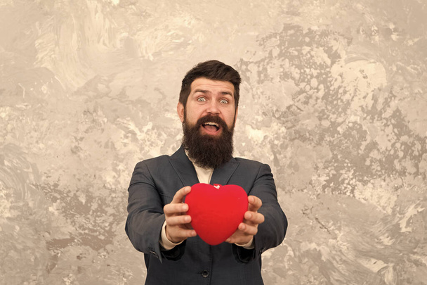 Love increases his cardiac output. Bearded man give red heart. Love symbol. Hipster celebrate Valentines day. Falling in love. Holiday of love and romance. February 14 - Фото, изображение