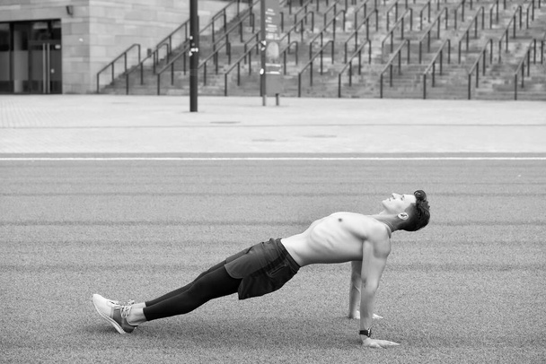 Sporty Man Making back Plank Exercise. guy in reverse plank exercise. Yoga fitness man stretching body in upward plank pose. doing reverse planking exercise outdoor on park grass. total body strength - Fotoğraf, Görsel